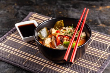 Asya mutfağı kavramı. Tay Tom yam tavuk suyu ve Hindistan cevizi sütü, mantar, tavuk, kırmızı biber ve sebze çorbası. Japon çanak siyah. Üstten görünüm, kopya alanı