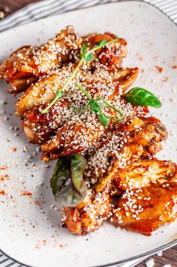 Amerikan mutfağı kavramı. Kızarmış tavuk budu kırmızı biber ile beyaz tabakta susam ile sırlı. Bir menü Restoranlar veya kafe için arka plan resmi. kopya alanı