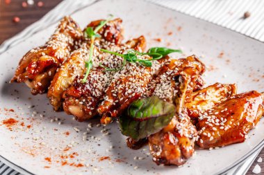 Amerikan mutfağı kavramı. Kızarmış tavuk budu kırmızı biber ile beyaz tabakta susam ile sırlı. Bir menü Restoranlar veya kafe için arka plan resmi. kopya alanı