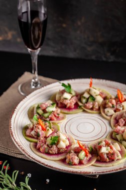 İspanya mutfağı kavramı. Meze Tapas. Taze ton balıklı tartar, midye, salatalık, elma, limon, acı, yeşil soğan, zeytin yağı. Seramik bir plaka üzerinde bir restoranda yemekler sunan. arka plan resmi.