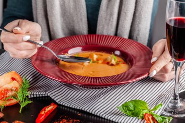 İspanya mutfağı kavramı. Restoranda kız gazpacho çorbası vardır ve kırmızı şarap içiyor. Çorbaya limon sıkarak.