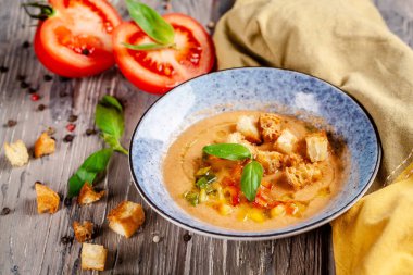 İspanya mutfağı kavramı. Domates taze domates Gazpacho çorbası. Çok güzel bir restoranda ahşap bir masa mavi bir tabağa yemekleri sunan. arka plan görüntüsü. kopya alanı 