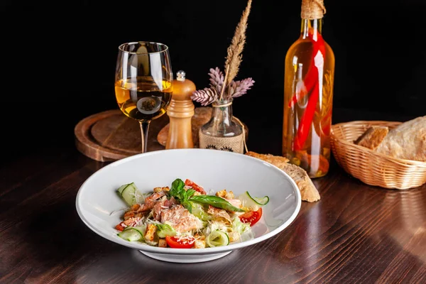 意大利美食的概念 凯撒沙拉配三文鱼 生菜混合物 樱桃和帕玛森奶酪 桌上一杯白葡萄酒 客人可以在餐厅享用菜肴 复制空间 — 图库照片