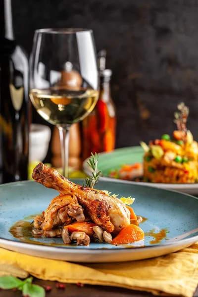 意大利美食的概念 用烈性酒煮鸡和蔬菜 在餐厅用蓝色盘子供应菜肴 白葡萄酒雪利酒在桌子上的杯子里 复制空间 — 图库照片