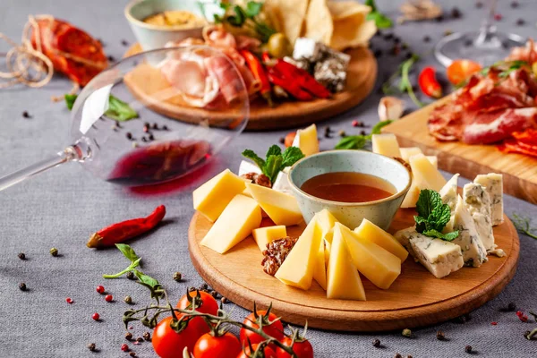 Italian food. Assortment of appetizers for a large company in a restaurant. Different types of smoked meat, sausages and cheeses. a glass of cool wine.