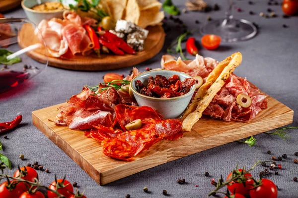 意大利菜 餐馆里一家大公司的开胃菜的分类 不同类型的熏肉 香肠和奶酪 一杯清凉的酒 — 图库照片