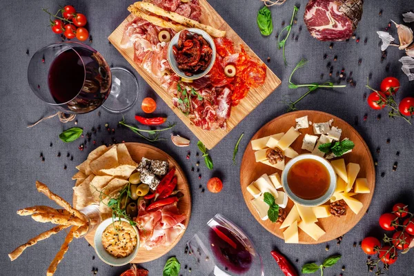 Italian food. Assortment of appetizers for a large company in a restaurant. Different types of smoked meat, sausages and cheeses. a glass of cool wine.