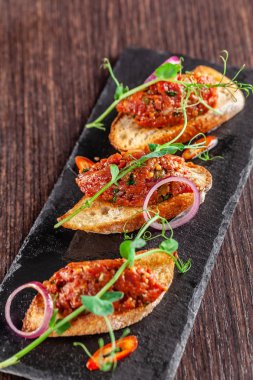 Meksika mutfağı kavramı. Biftek tartare maydanoz ile Fransız hardalı baget kruton üzerinde fasulye. Üzerinde siyah bir taş barut restoranda bir yemek. Arka plan görüntüsü. kopya alanı