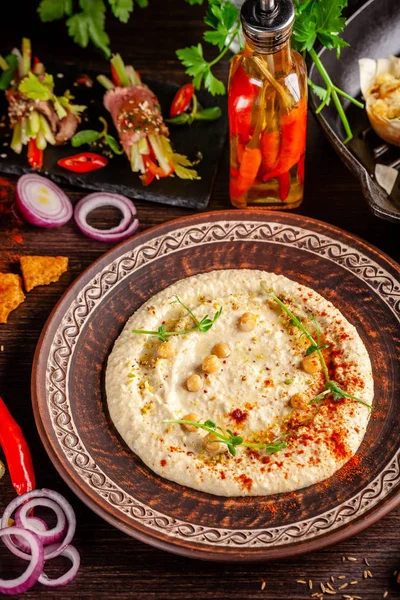 The concept of Arabic cuisine. Oriental hummus with grilled sesame and pistachios. Laid arabic table for the holiday. Background image. Top view, copy space