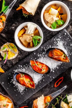 Avrupa mutfağı. meze şarap siyah bir arka plan için. Pate, mini salata, kanepe, deniz ürünleri, somon ve domates soslu midye. Üstten Görünüm, kopya alanı
