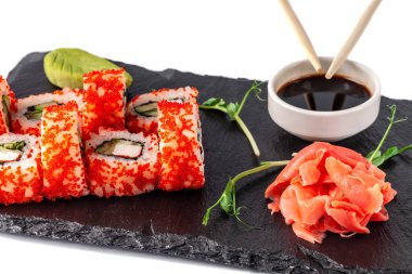 Japon mutfağı kavramı. Yengeç sopa, salatalık ve kereviz, kırmızı havyar ile rulo. Soya sosu, zencefil ve wasabi. Siyah arduvaz yazı tahtası üzerinde restoranda modern hizmet yemeklerin. ������