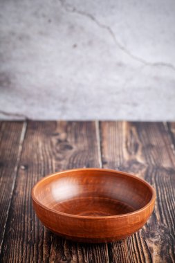 Boş bir levha kırmızı kil ahşap bir masa üzerinde kopya alanı standları