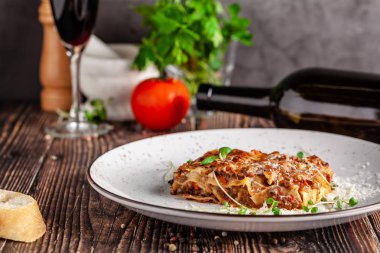 İtalyan mutfağı kavramı. Lazanya kıyma, beşamel sos ve parmesan peyniri. Yakın çekim. Beyaz bir tabak içinde bir restoranda yemekler sunan. kopya alanı