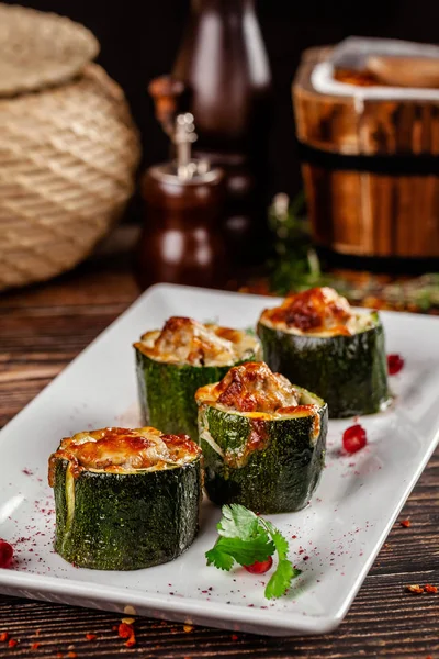 Gürcü mutfağı kavramı. Kıyılmış kuzu etli kabak dolması Suluguni peynir. Beyaz bir plaka üzerinde bir restoranda yemekler Nar ile hizmet. kopya alanı, arka plan görüntüsü