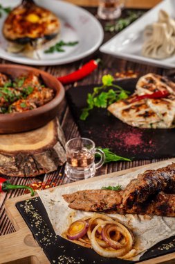 Gürcü mutfağı. Büyük bir tablo farklı yemekler tüm aile için bir günde işten. Kebap, Lula, lavaş, Suluguni peynir, Khachipuri, Hıngel.