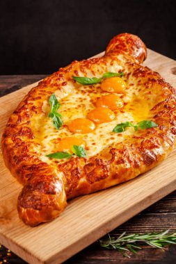 Gürcü mutfağı. Bir ahşap tahta üzerinde 5 yumurta sarısı ile büyük khachapuri. İnsanların büyük bir şirket için bir restoranda bir yemek. Arka plan görüntü kopyalama alanı