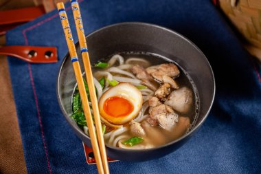 Pan-Asya Mutfağı kavramı. Japon Ramen Çin eriştesi, yumurta, tavuk ve yeşil soğan çorbası. Kabın içinde restoranda yemekler sunan. Arka plan görüntüsü. kopya alanı