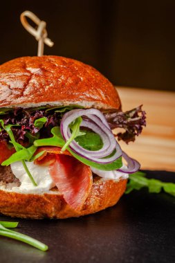 Italyan ev pişirme kavramı. Biftek ve domuz eti cutlet, mozzarella peyniri, salam sosis, Parma, roka ve marul karışımı ile Burger. Restoranda servis güzel. 