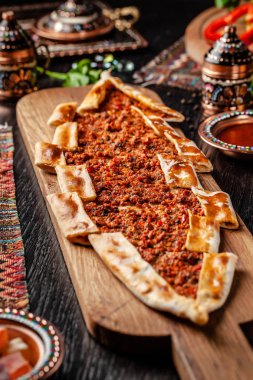 Traditional Turkish cuisine. Turkish pizza Pita with meat. Turk Pidesi or  Sucuk Pide. Beautiful serving dishes in the restaurant. Background image. copy space clipart