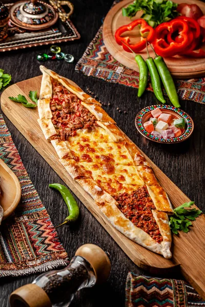 Традиционная турецкая кухня. Турецкая пицца Пита с другой начинкой, мясом, сыром, ломтиками телятины. Тёрк Пидези или Сукук Пидэ. Подавать блюда в ресторане. Копирование пространства — стоковое фото
