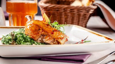 Bir Japon restoranında akşam yemeği konsepti. Ispanak baharatlı bir sos krema ve sırlı tavuk bacakları ile süsleyin. Bardakta erik şarabı. Arka plan görüntüsü. kopyalama alanı