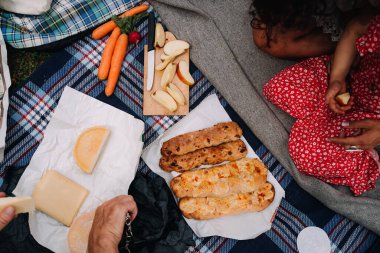 Piknikte çocuklarla eğlenen mutlu ailelerin fotoğrafı.