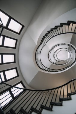 Büyük binanın sarmal merdivenlerinin derinliklerine bakıyorum.