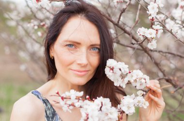 yakın çekim bir çiçek bahçesinde mavi gözlü kahverengi saçlı bir kadın portresi