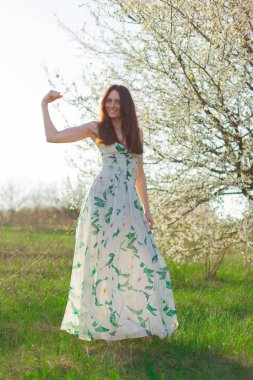 ince sportif kahverengi saçlı mavi gözlü parlak güneş ışığı tam büyüme çiçekli bahçesinde gösterir güçlü bir pazı