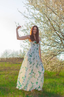 ince sportif kahverengi saçlı mavi gözlü parlak güneş ışığı tam büyüme çiçekli bahçesinde gösterir güçlü bir pazı