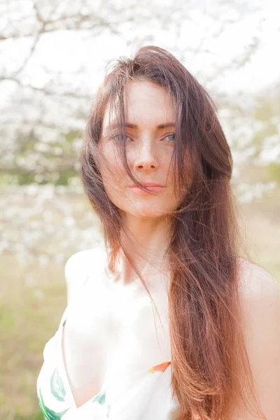 yakın çekim bir çiçek bahçesinde mavi gözlü kahverengi saçlı bir kadın portresi