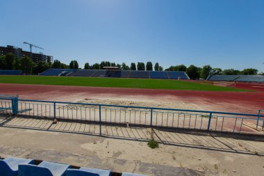 bir koşu parkuru ve arka plan binada bir futbol alanı doğal yeşil çim vinçler ile küçük ili stadyum