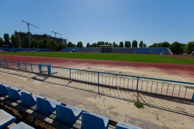 bir koşu parkuru ve arka plan binada bir futbol alanı doğal yeşil çim vinçler ile küçük ili stadyum