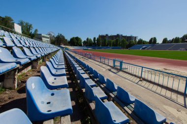 oturma parlak güneşli bir günde mavi Berrak gökyüzü mavi stadyum yeşil alan ve çalıştıran parça içinde