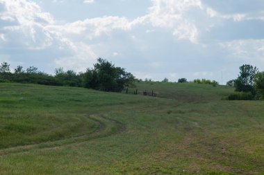 toprak yol yükselir çimlerin arasında bir tepe üzerinde gider ufuk ve beyaz bulut mavi sette