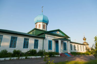 Altın bir haç ve bir mavi mavi kubbe köyü erken sabah güneşin Hıristiyan kilise