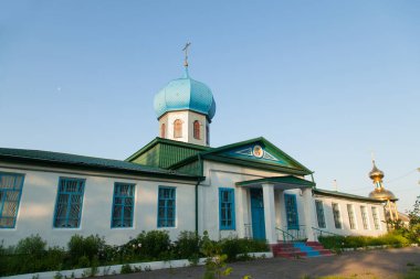 Altın bir haç ve bir mavi mavi kubbe köyü erken sabah güneşin Hıristiyan kilise