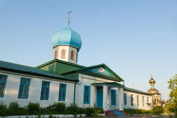 Altın bir haç ve bir mavi mavi kubbe köyü erken sabah güneşin Hıristiyan kilise