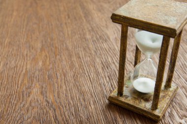 Kum saati zaman geçen kavram olarak meşe masada iş son tarih, aciliyet ve zamanın dışında çalışan.