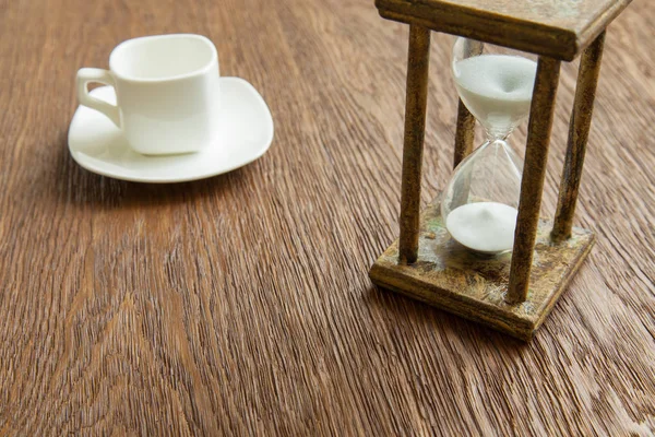 Kum saati zaman geçen kavram olarak meşe masada iş son tarih, aciliyet ve zamanın dışında çalışan.