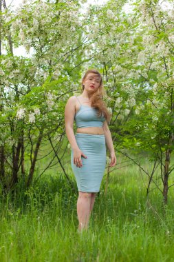 Ukraynalı kız dar elbise beyaz akasya çiçekleri karşı poz