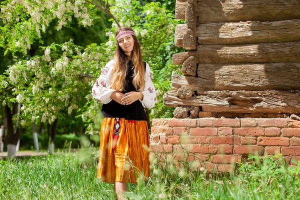 村の納屋の木製フレームの背景に刺繍の美しいスレンダー ウクライナの女性 — ストック写真