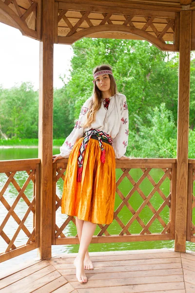 美丽的乌克兰妇女身着刺绣在一个木制夏天 Altanka — 图库照片