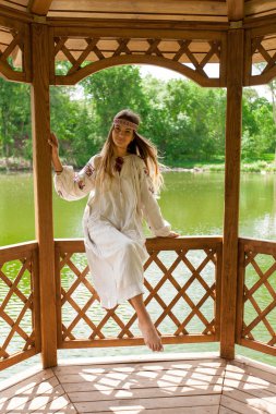 Güzel ince Ukrayna nakış rüzgarlı havalarda içinde bir dinlenme göl kenarında yaz güneşli bir günde sahiptir.