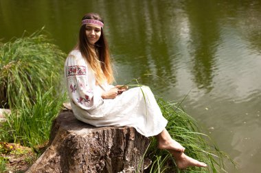 Güzel ince Ukrayna dili nakış gölün kıyısında güneşli bir yaz doğası sahiptir