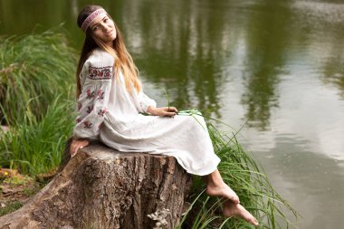 Güzel ince Ukrayna dili nakış gölün kıyısında güneşli bir yaz doğası sahiptir