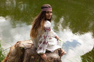 Güzel ince Ukrayna dili nakış gölün kıyısında güneşli bir yaz doğası sahiptir