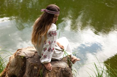 Güzel ince Ukrayna dili nakış gölün kıyısında güneşli bir yaz doğası sahiptir