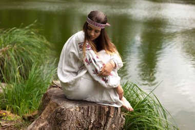 Güzel ince Ukrayna dili nakış gölün kıyısında güneşli bir yaz doğası sahiptir