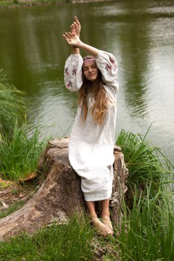 Güzel ince Ukrayna dili nakış gölün kıyısında güneşli bir yaz doğası sahiptir